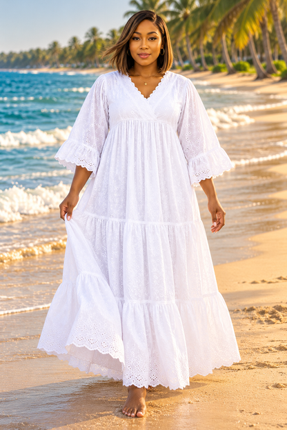 Robe longue blanche en broderie anglaise sur la plage au coucher du soleil